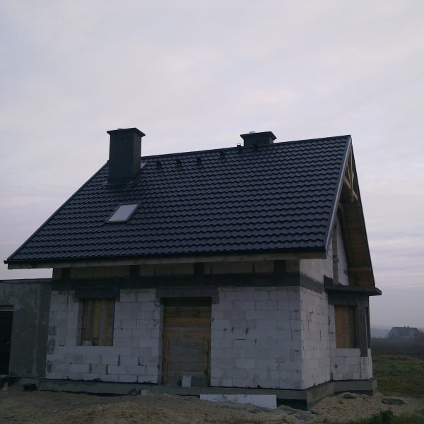 Stylowy dach z blachodachówki Ruukki Finnera czarna o połyskującym wykończeniu.
